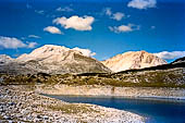 Parco Naturale Fanes-Senes-Braies. Escursione al Rifugio Fanes. Il passo Limo 2174 m. e il suo  lago. Sullo sfondo la Cima delle Nove (sinistra) e il monte Sella di Fanes (destra).